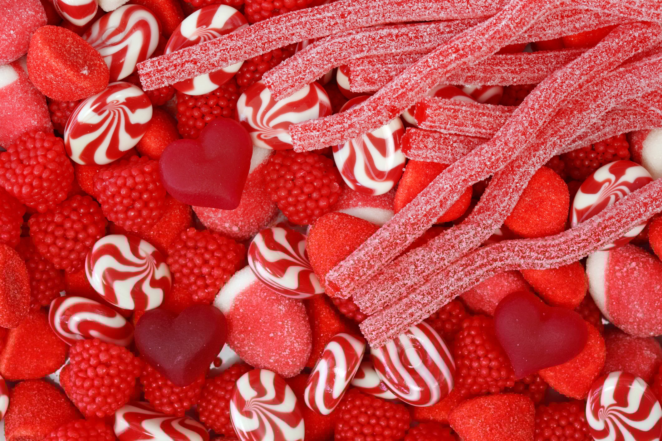 A close up of various red-coloured sweets.