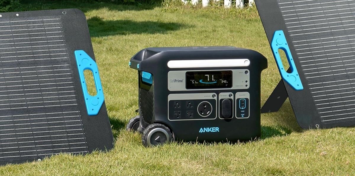 the anker solix f2000 portable power station sits in a lawn with a solar panel positioned on both sides.